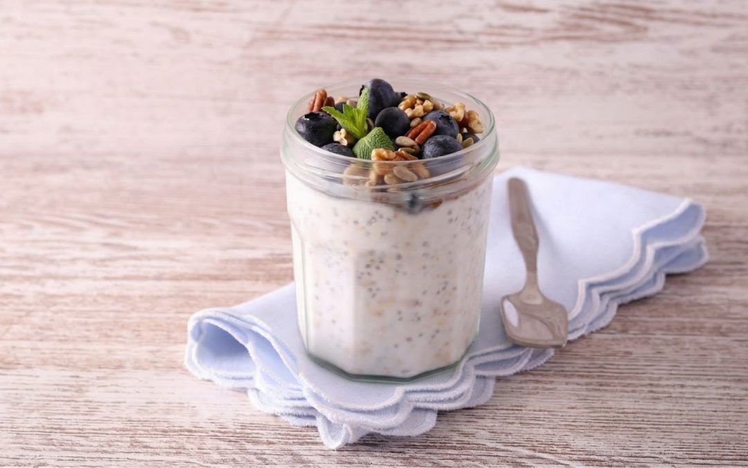 Blueberry chia overnight oats in a glass jar topped with fresh blueberries and chia seeds, a healthy high-fibre breakfast for morning energy and gut health.
