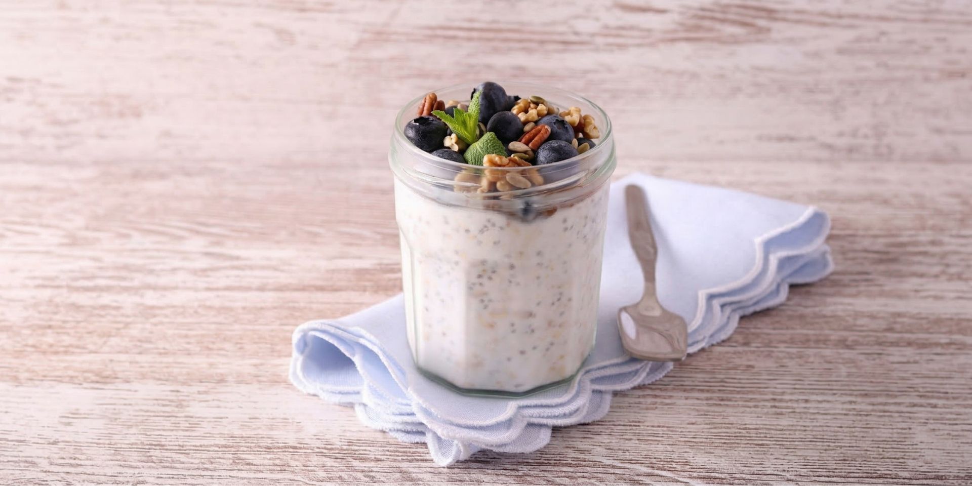 Blueberry chia overnight oats in a glass jar topped with fresh blueberries and chia seeds, a healthy high-fibre breakfast for morning energy and gut health.