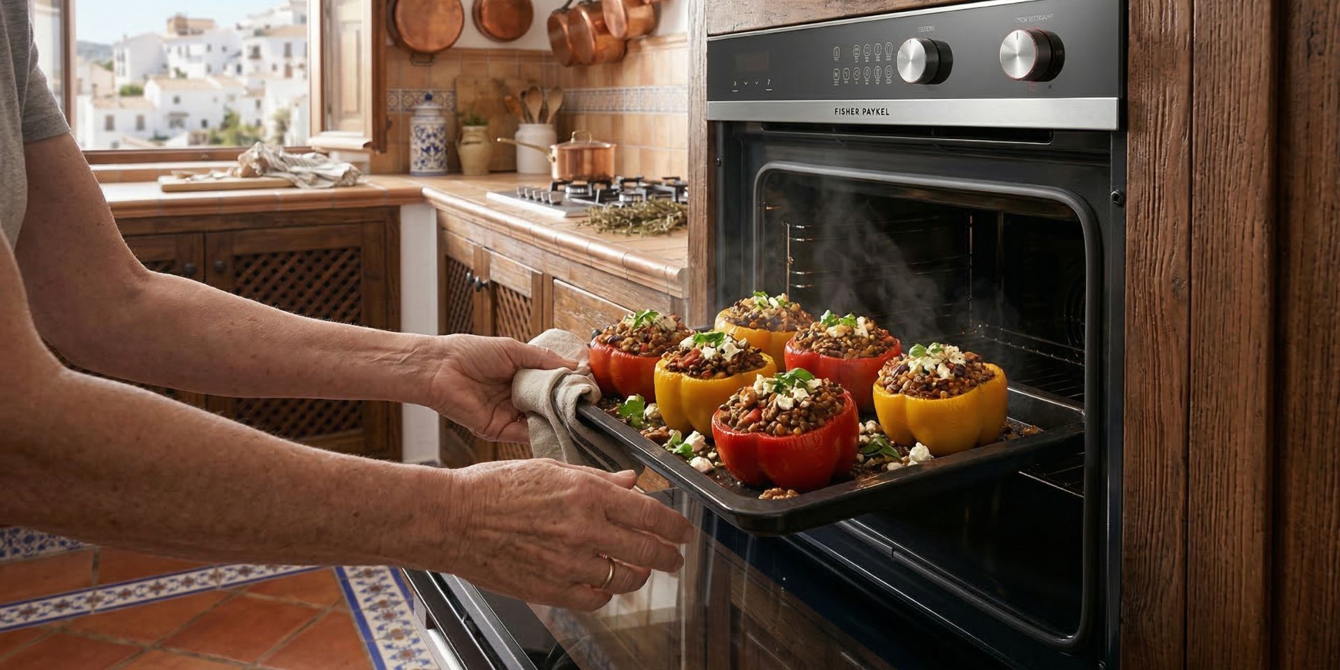 Tray of Mediterranean lentil and walnut stuffed bell peppers being removed from the oven in a rustic kitchen.